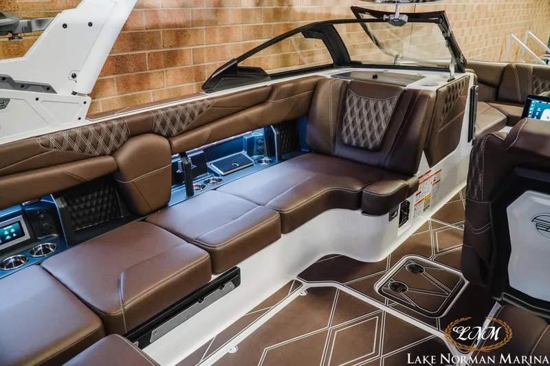 Slide: The Image of Luxurious interior of 2025 Malibu M230 boat with brown leather seating and modern design. - 18