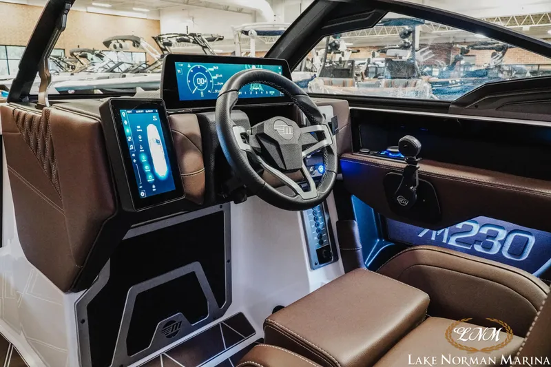 Slide: The Image of 2025 Malibu M230 boat interior with modern dashboard and digital controls at Lake Norman Marina. - 21
