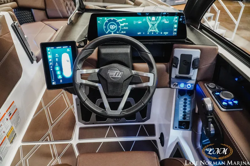 Slide: The Image of 2025 Malibu M230 boat dashboard with advanced digital controls and sleek design at Lake Norman Marina. - 22