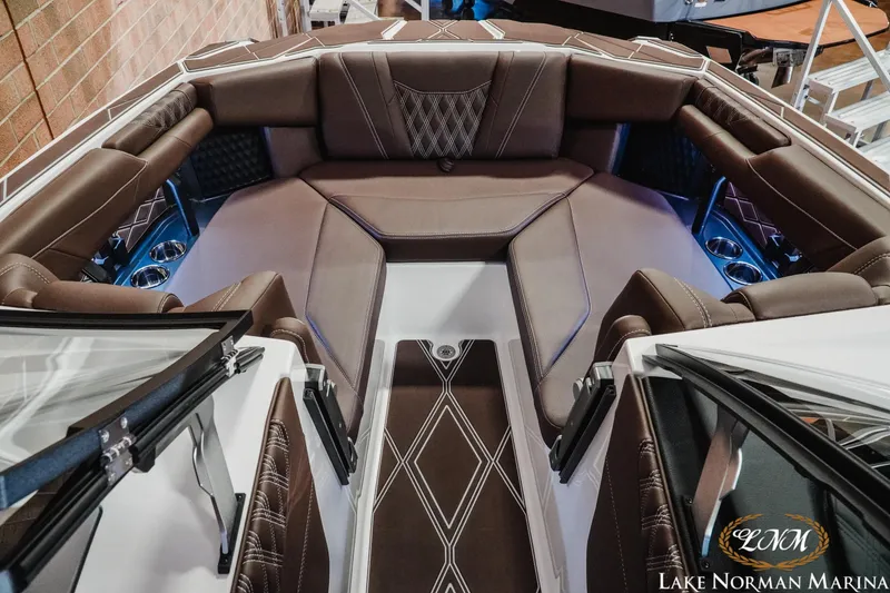 Slide: The Image of 2025 Malibu M230 boat interior with luxurious brown seating and modern design. - 24