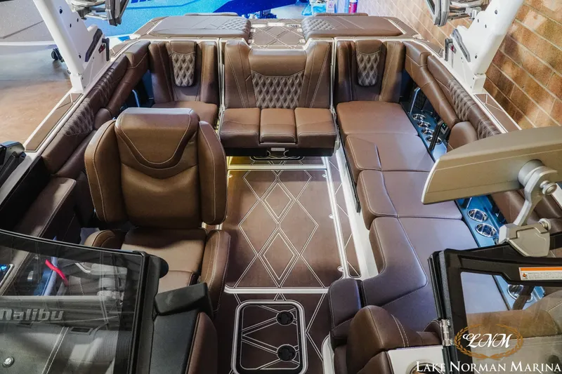 Slide: The Image of Luxurious interior of 2025 Malibu M230 boat with brown leather seating and modern design. - 25