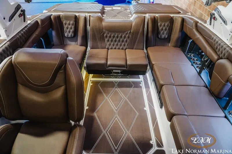 Slide: The Image of Luxurious interior of 2025 Malibu M230 boat with brown leather seating and elegant design. - 26