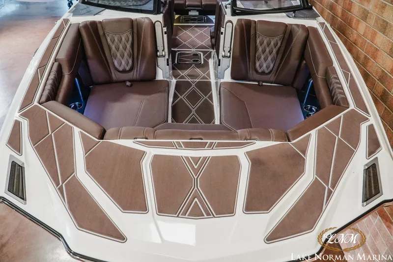 Slide: The Image of 2025 Malibu M230 boat interior with luxurious brown seating and geometric design. - 5