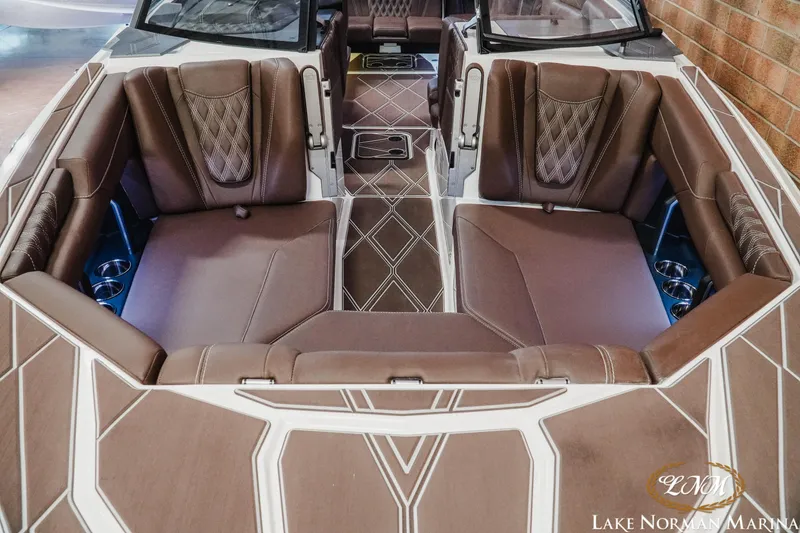 Slide: The Image of 2025 Malibu M230 boat interior with luxurious brown seating and diamond-patterned design. - 6