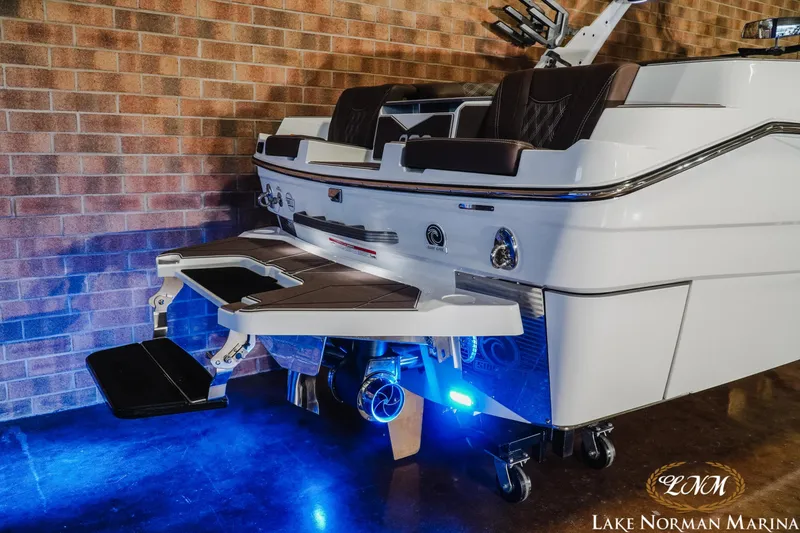 Slide: The Image of 2025 Malibu M230 boat with illuminated swim platform, showcased at Lake Norman Marina. - 8