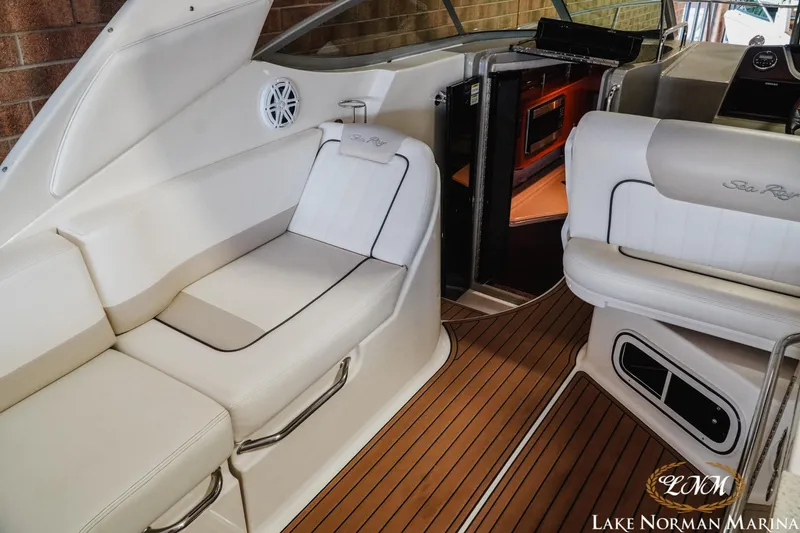 Slide: The Image of Interior of 2011 Sea Ray 280 Sundancer with white seating and wood flooring at Lake Norman Marina. - 13