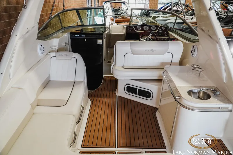 Slide: The Image of 2011 Sea Ray 280 Sundancer interior with seating, helm, and kitchenette at Lake Norman Marina. - 7