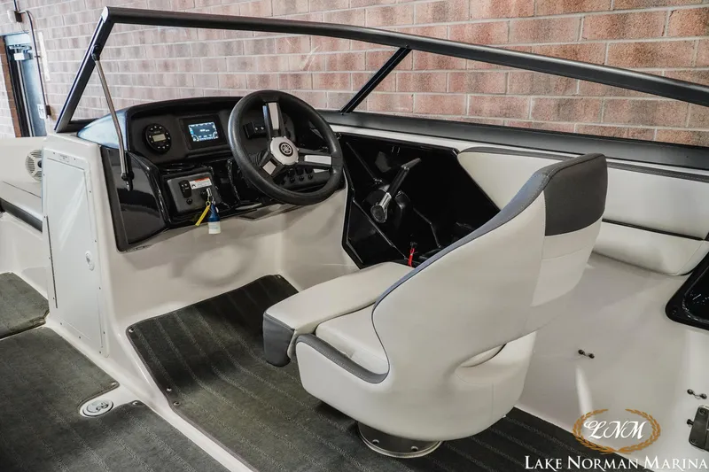 Slide: The Image of 2022 Yamaha Boats AR 190 interior with steering wheel and captain's seat at Lake Norman Marina. - 9