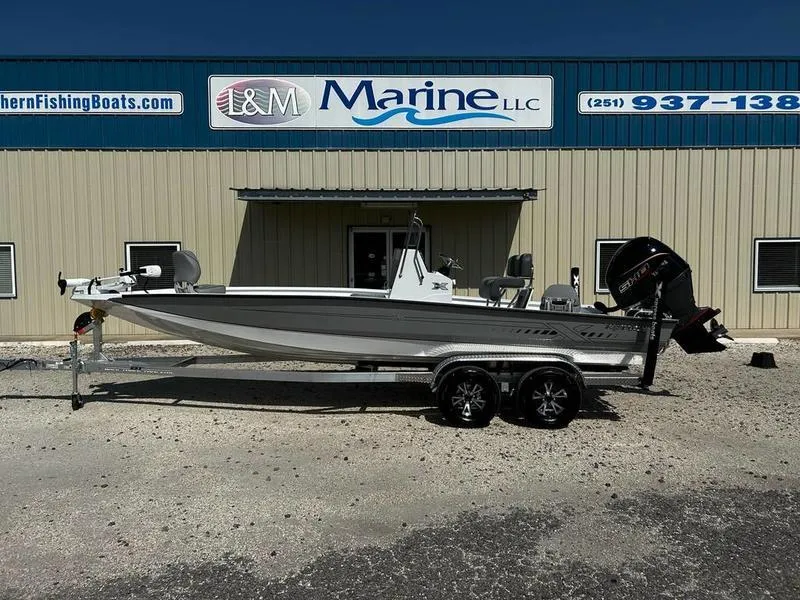 Slide: The Image of 2025 Xpress H22B boat on trailer outside L&M Marine LLC building. - 0
