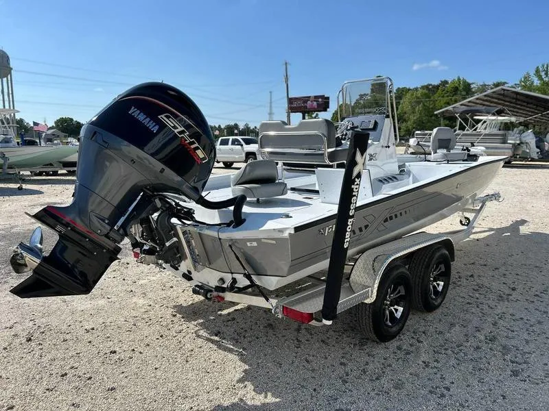 Slide: The Image of 2025 Xpress H22B boat with Yamaha engine on a dual-axle trailer, parked outdoors. - 1