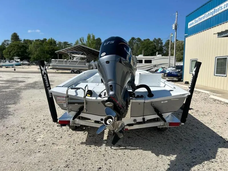Slide: The Image of 2025 Xpress H22B boat with powerful outboard motor, parked outdoors near a boat dealership. - 14
