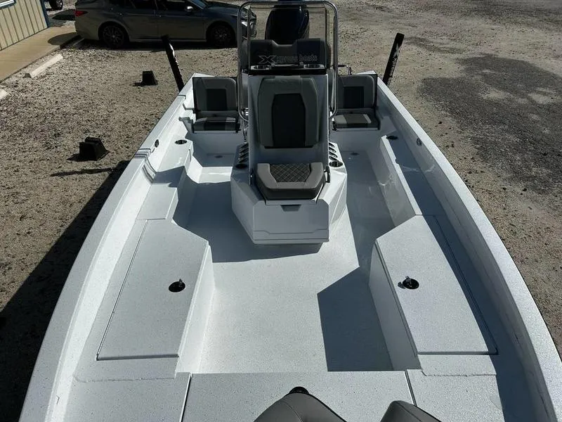 Slide: The Image of 2025 Xpress H22B boat with spacious deck and seating, parked outdoors. - 3