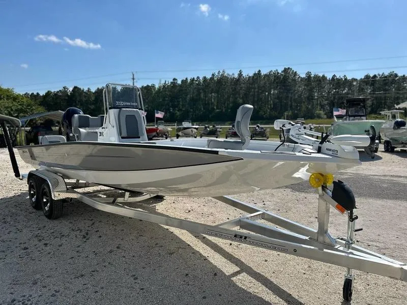 Slide: The Image of 2025 Xpress H22B boat on trailer, parked outdoors under clear blue sky. - 6
