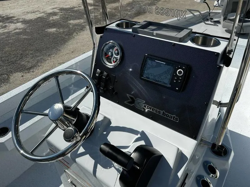 Slide: The Image of 2025 Xpress H22B boat dashboard with steering wheel and navigation controls. - 7
