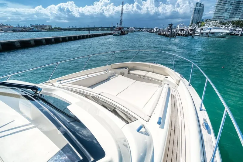 Slide: The Image of 2018 Chris-Craft Launch boat on turquoise water near marina, clear sky, and cityscape. - 6