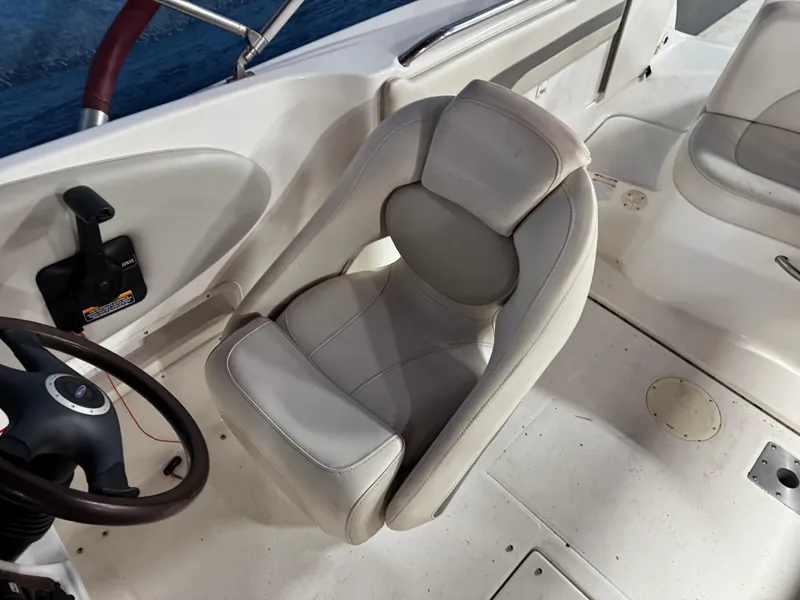 Slide: The Image of 2005 Chaparral Sunesta 232 boat interior with steering wheel and cushioned seat. - 10