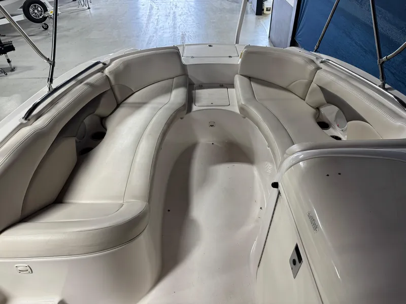Slide: The Image of 2005 Chaparral Sunesta 232 boat interior with spacious seating and white upholstery. - 12