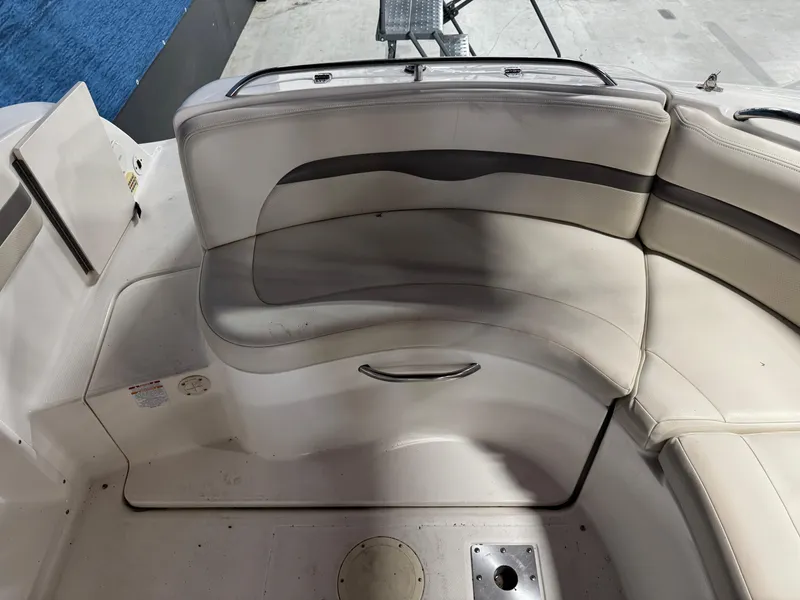 Slide: The Image of 2005 Chaparral Sunesta 232 boat interior seating, featuring white and gray cushioned seats. - 7