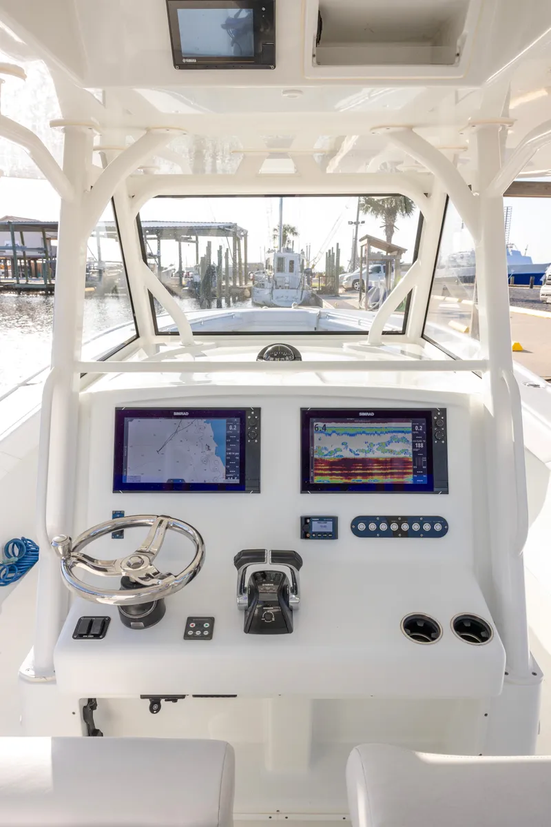 Slide: The Image of 2019 Yellowfin 39 Offshore boat dashboard with navigation screens and steering wheel. - 10