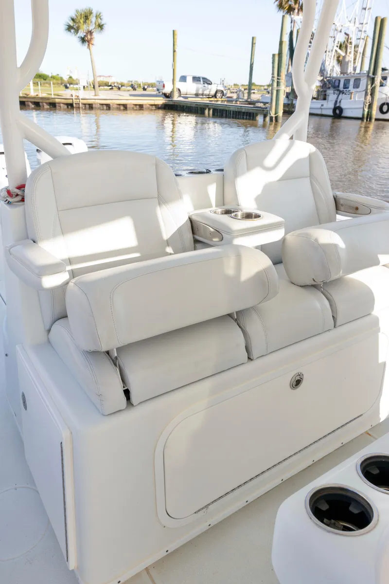 Slide: The Image of 2019 Yellowfin 39 Offshore boat with white cushioned seating, docked by the water. - 11