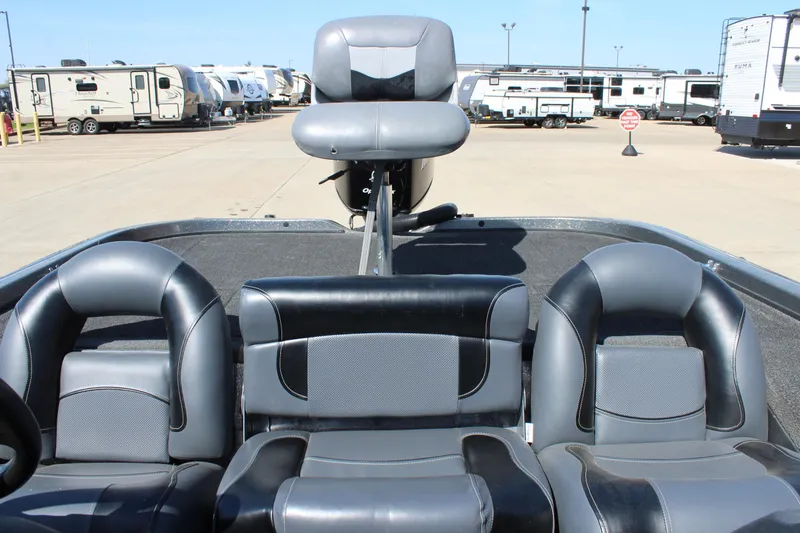 Slide: The Image of 2005 Nitro 901 CDX boat interior with black and gray seating, parked near RVs. - 10