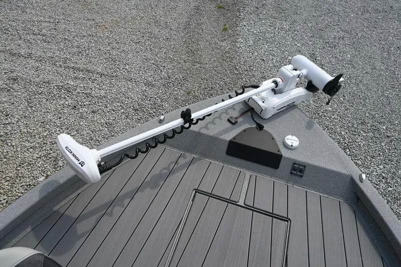 Slide: The Image of 2025 Vexus ACX2210 boat deck with trolling motor on gravel surface. - 4