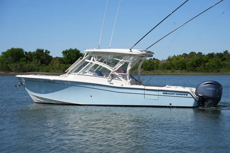 Slide: The Image of 2022 Grady-White Freedom 285 boat on calm water, side view, clear sky. - 0