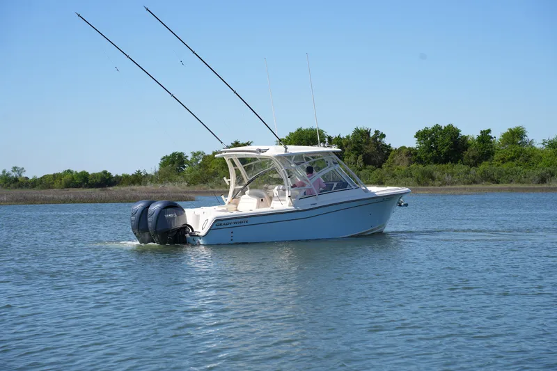 Slide: The Image of 2022 Grady-White Freedom 285 boat cruising on a calm lake with clear blue skies. - 10