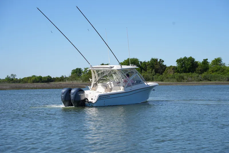 Slide: The Image of 2022 Grady-White Freedom 285 boat cruising on a calm lake with clear blue skies. - 11
