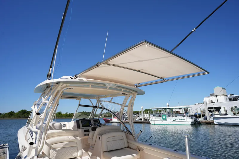 Slide: The Image of 2022 Grady-White Freedom 285 boat with open canopy, docked in a marina. - 21
