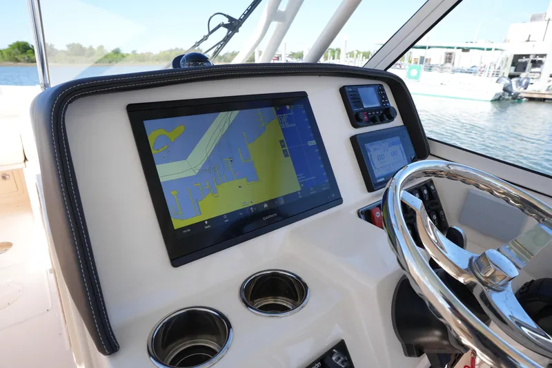 Slide: The Image of 2022 Grady-White Freedom 285 boat dashboard with navigation display and steering wheel. - 27