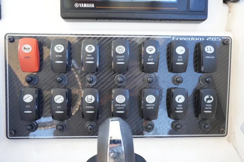 Slide: The Image of Control panel of 2022 Grady-White Freedom 285 boat with labeled switches. - 34