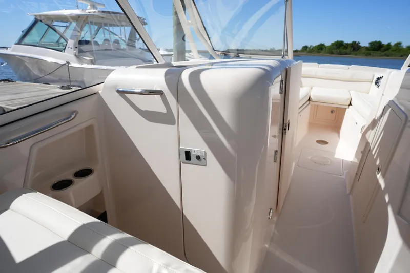 Slide: The Image of 2022 Grady-White Freedom 285 boat interior with seating and storage, docked by the water. - 39