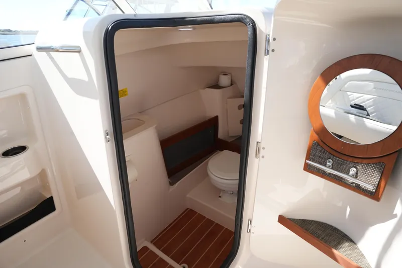 Slide: The Image of 2022 Grady-White Freedom 285 boat interior with compact bathroom and wooden accents. - 40