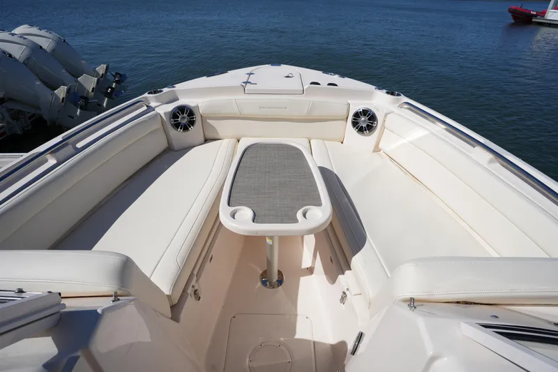 Slide: The Image of 2022 Grady-White Freedom 285 boat interior with seating and table, on calm water. - 45