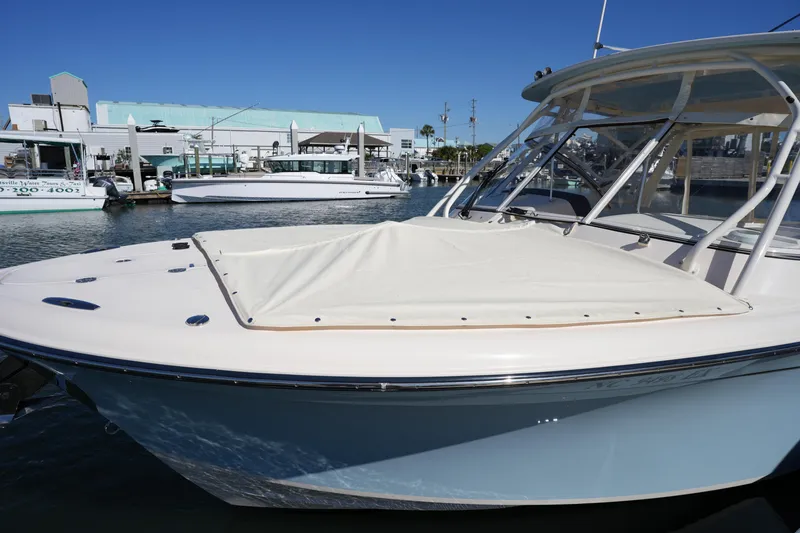 Slide: The Image of 2022 Grady-White Freedom 285 boat docked at marina under clear blue sky. - 46