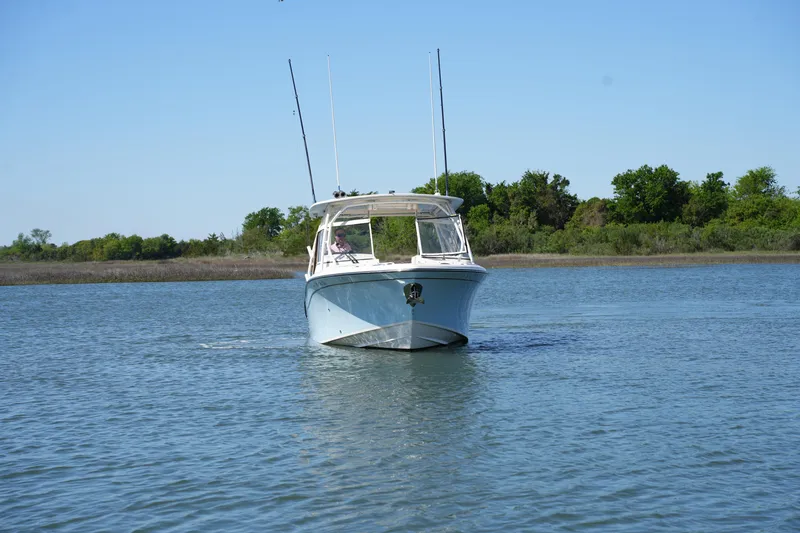 Slide: The Image of 2022 Grady-White Freedom 285 boat cruising on a calm lake. - 5