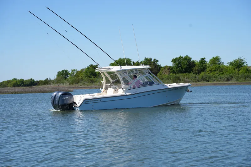 Slide: The Image of 2022 Grady-White Freedom 285 boat cruising on a calm lake with clear blue skies. - 9