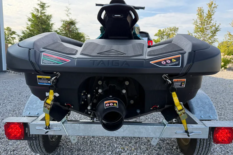 Slide: The Image of 2024 Taiga Orca jet ski on trailer, rear view, parked on gravel. - 5