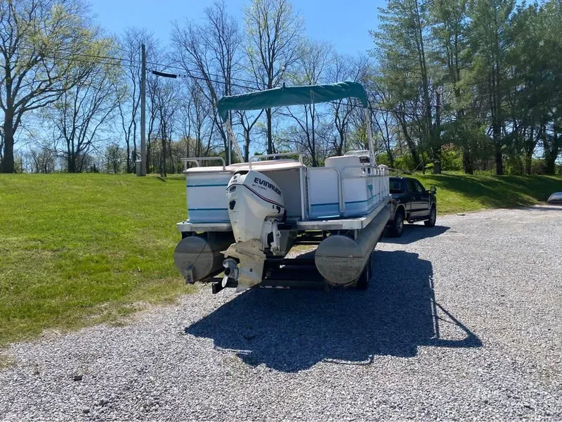 Slide: The Image of 2023 Parti Kraft 240 SC pontoon boat on trailer, parked on gravel, surrounded by trees. - 3