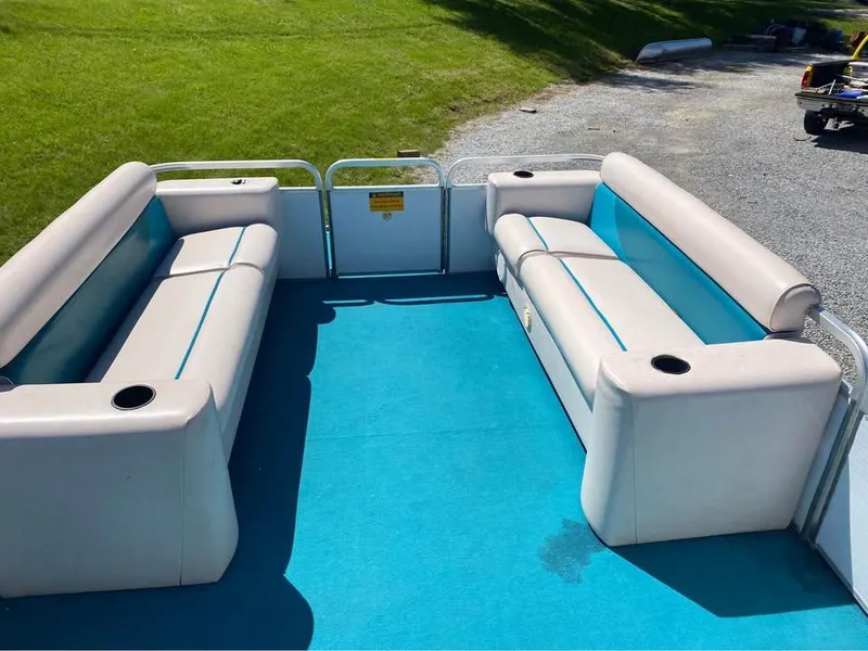 Slide: The Image of 2023 Parti Kraft 240 SC pontoon boat interior with blue carpet and beige seating. - 4