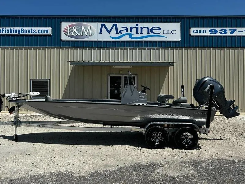 Slide: The Image of 2025 Xpress H210B boat on trailer outside I&M Marine LLC building. - 0