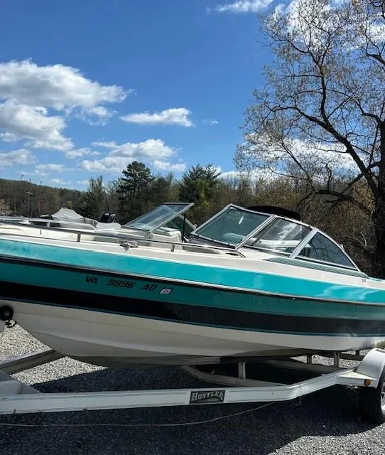 Slide: The Image of 1992 Caravelle 2000 boat on trailer under blue sky and trees. - 4
