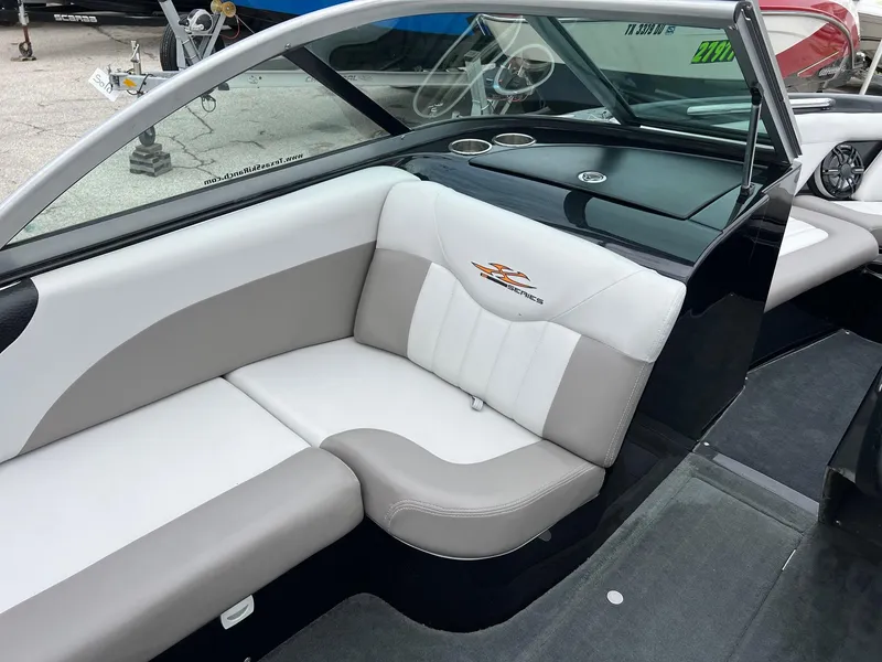 Slide: The Image of 2006 MasterCraft X1 boat interior with beige and white seating, sleek design, and cup holders. - 11