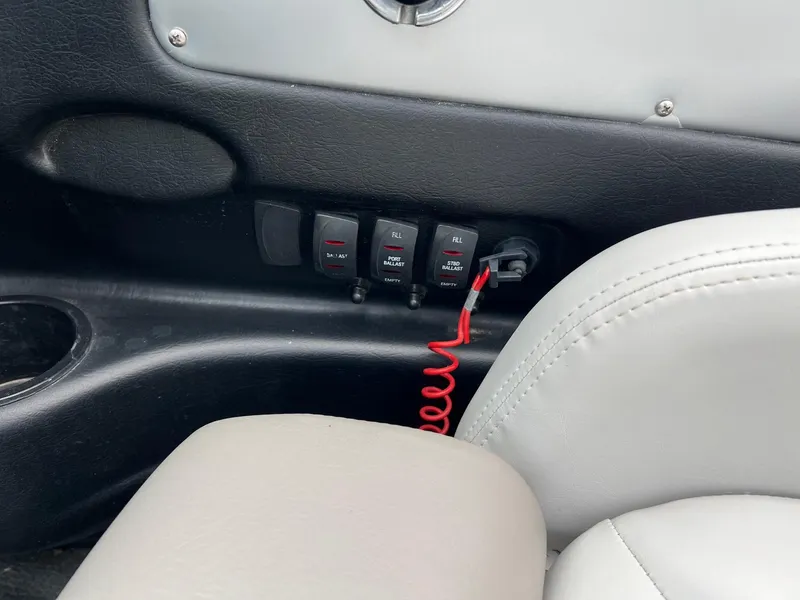 Slide: The Image of 2006 MasterCraft X1 boat interior with control switches and red safety cord. - 15