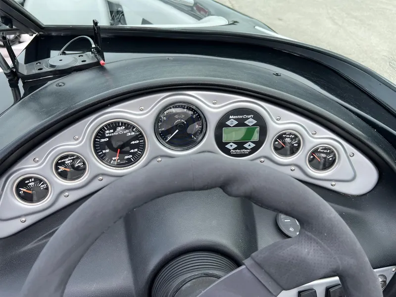 Slide: The Image of Dashboard of a 2006 MasterCraft X1 boat with gauges and steering wheel. - 16