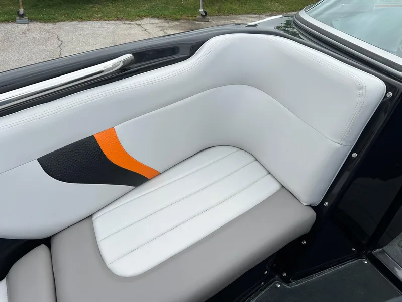 Slide: The Image of 2006 MasterCraft X1 boat interior with white and gray seating, orange accent. - 19