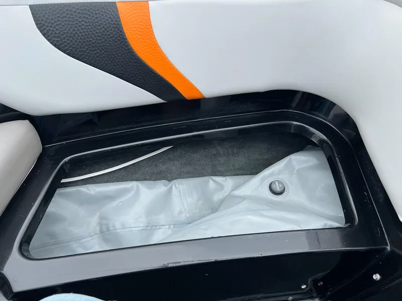 Slide: The Image of Interior storage compartment of a 2006 MasterCraft X1 boat with orange and black accents. - 22