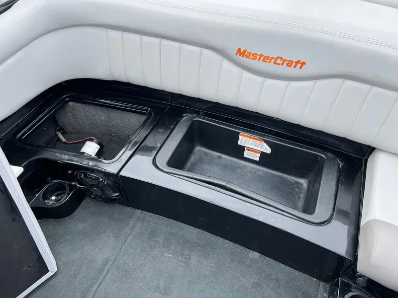 Slide: The Image of 2006 MasterCraft X1 boat interior storage compartments with logo. - 26
