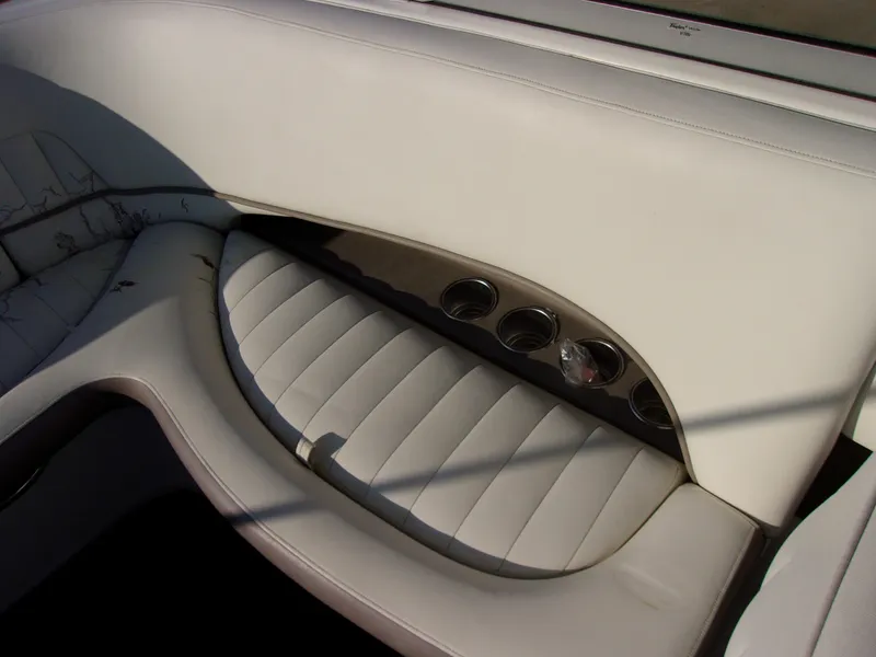 Slide: The Image of 2004 Cobalt 240SD boat interior with white leather seating and cup holders. - 11